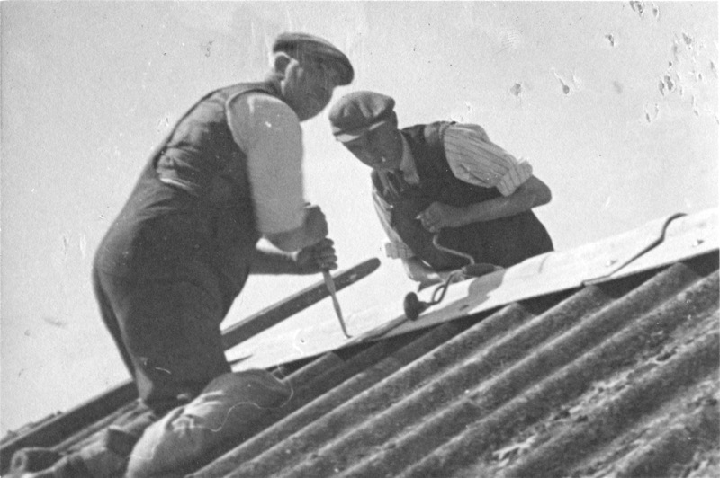 Photograph of two men workig on roof