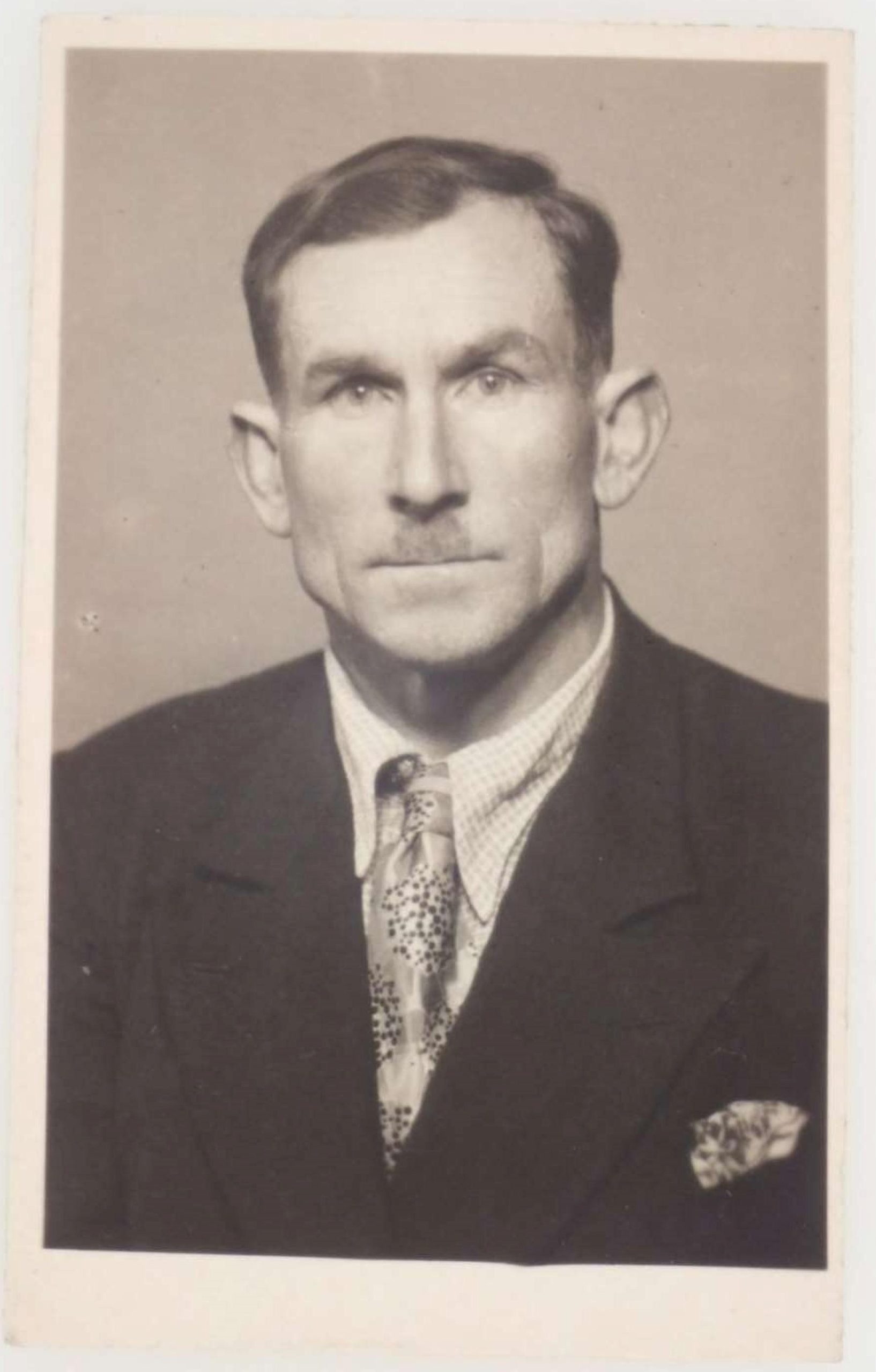 Portrait photograph of man with mustache wearing suit